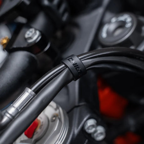 Chigee silicone kabelbeheerset with cable ties and clips for organized cable management on a desk or electronic setup.